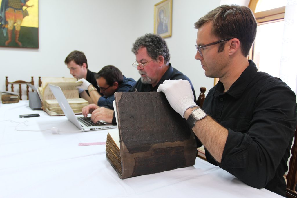 Scholars examine manuscripts.